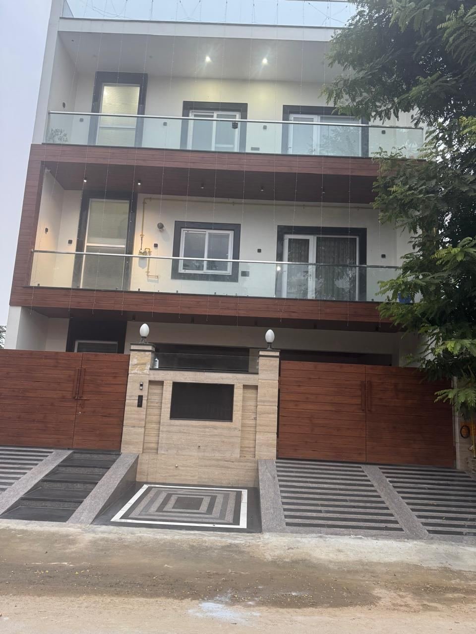 Four-floor builder floor front elevation with jali screen, glass balconies and wooden cladding by GharVistaar builder floor construction Delhi